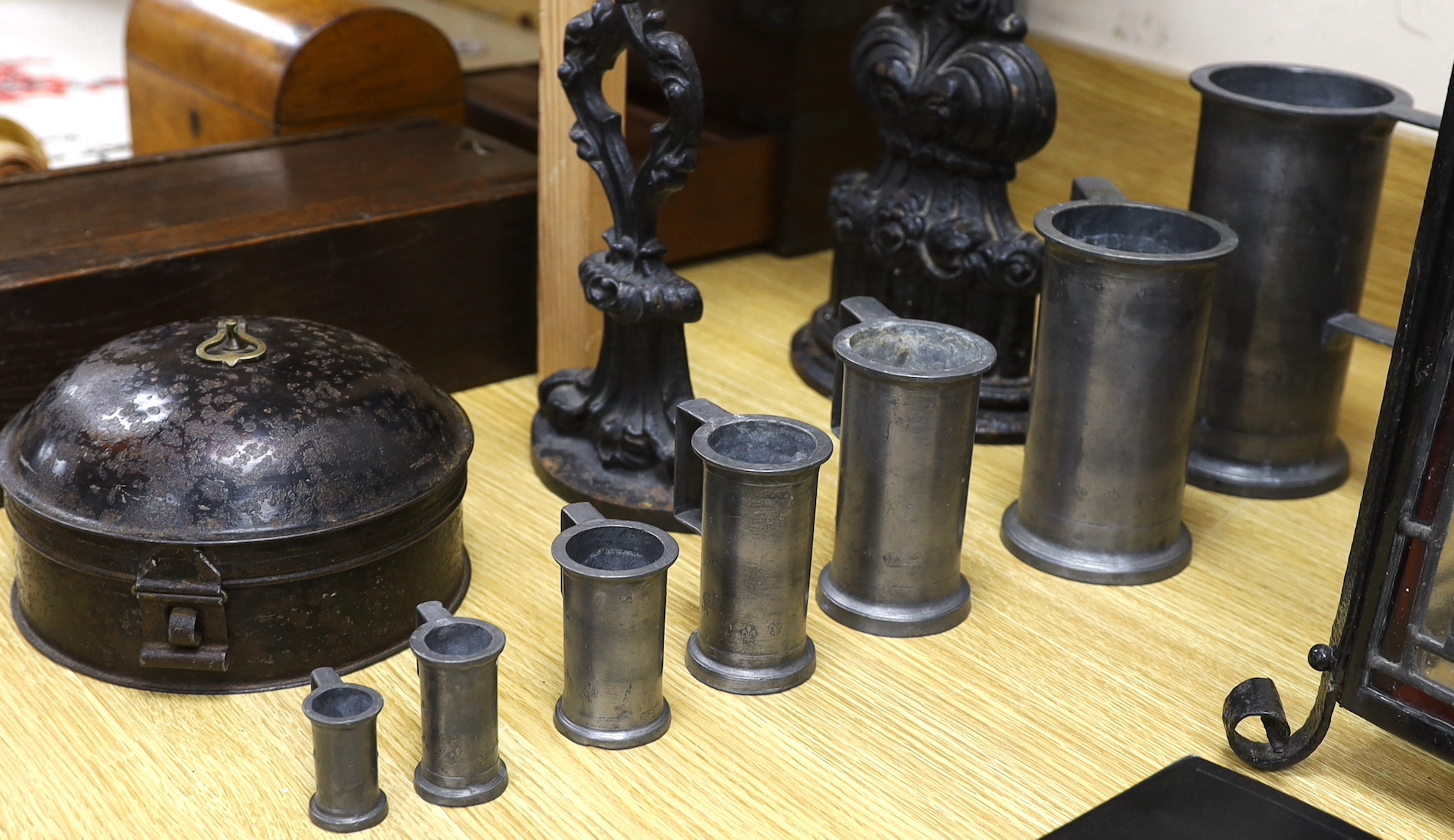 A graduated set of seven French pewter measures, a toleware spice box and two cast iron door stops (10), tallest door stop 39cms high